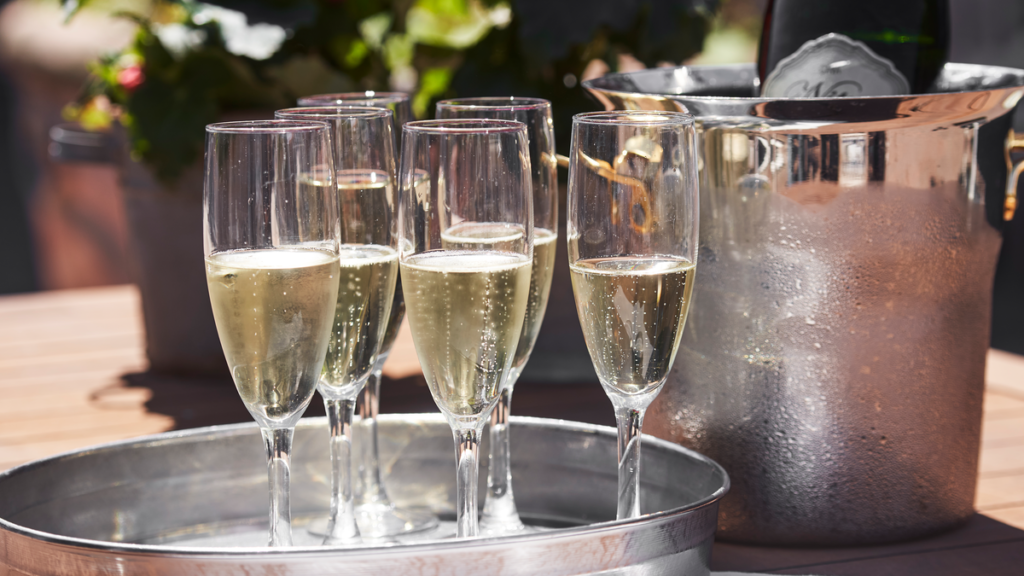 Champagne i glas på sølvfad der står ude til vores gæster