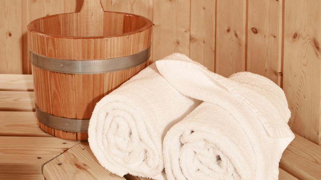 Spand med vand og håndklæder til afbenyttelse i vores lækre sauna