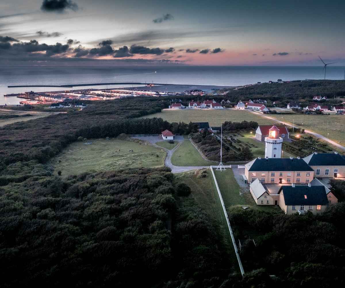 Hanstholm Fyr ved solnedgang med udsigt over havn og Vesterhavet i Nordjylland